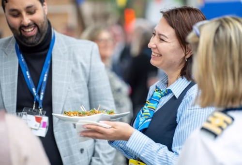People at an event enjoying conversation and food