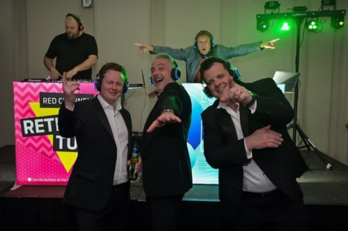 A group of people at an event dancing and posing to the camera