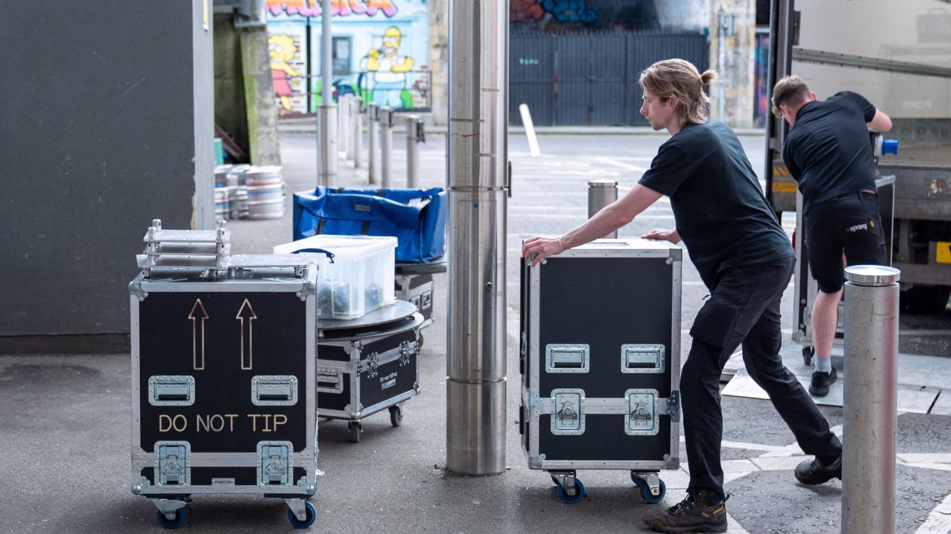 Man pushing Sparq branded box's with technical event equipment inside