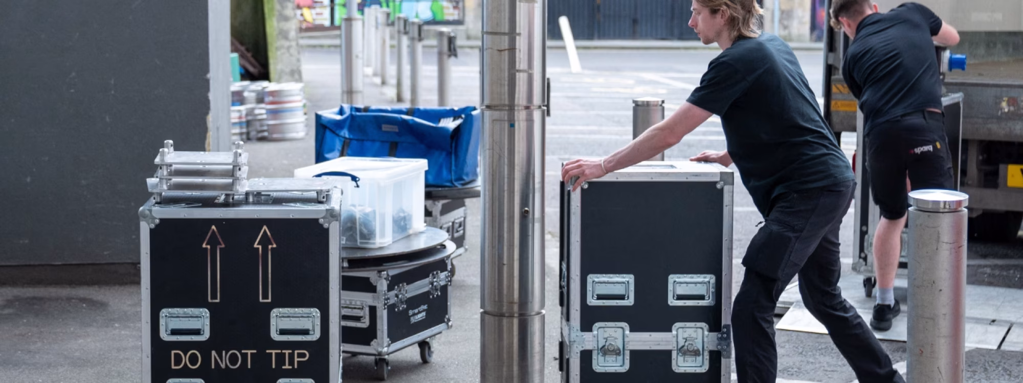 Man pushing Sparq branded box's with technical event equipment inside